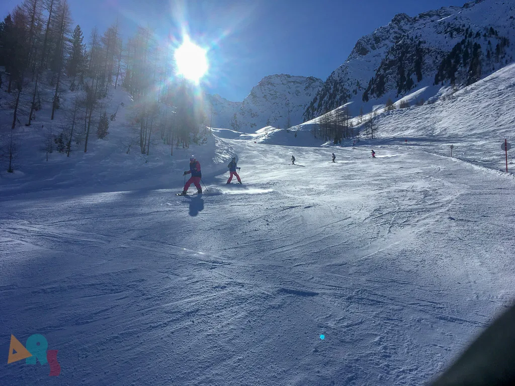 Piste im Gegenlicht mit einzelnen Fahrenden.